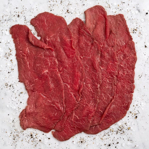 Λεπτοκομμένες φέτες παγιάρ μοσχαρίσιου Black Angus Αργεντινής, ψημένες στο τηγάνι και σερβιρισμένες με λεμόνι και σαλάτα.